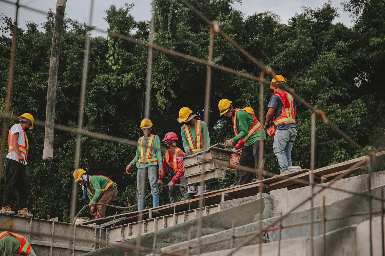 Construction crew in hard hats and hi-vis vests working safely on a jobsite