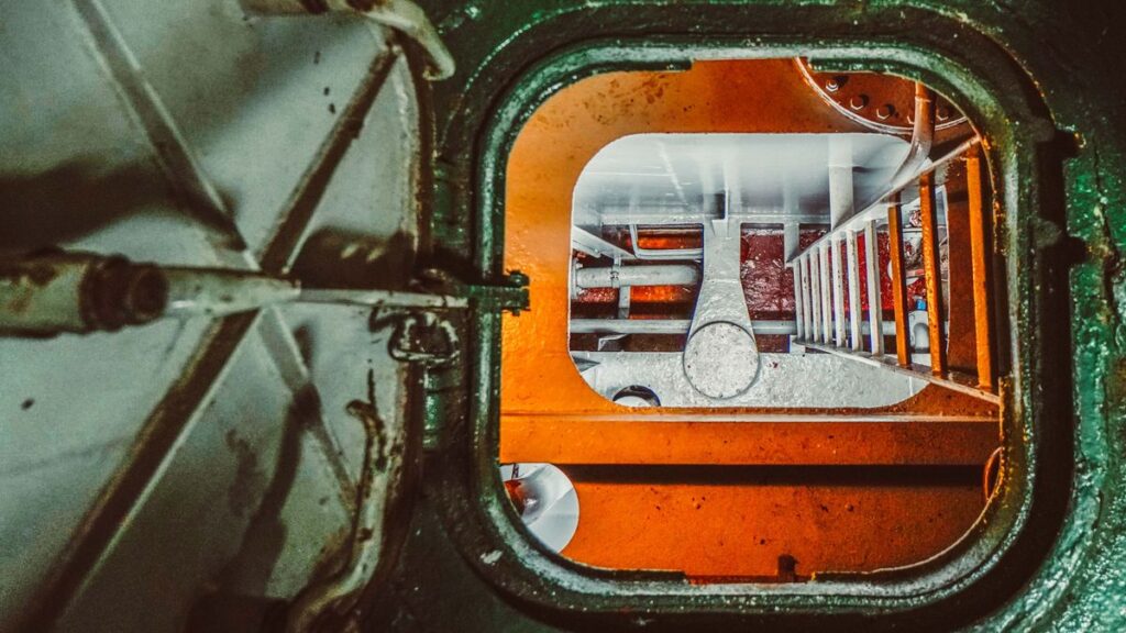 Overhead view of a metal storage tank hatch with an internal ladder, a permit-required confined space entry point