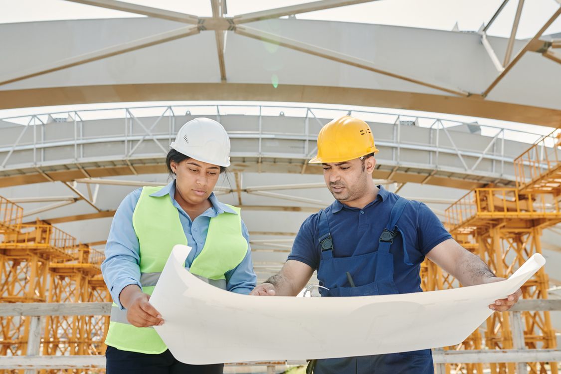 Construction crew performing a job hazard analysis while reviewing plans before a task