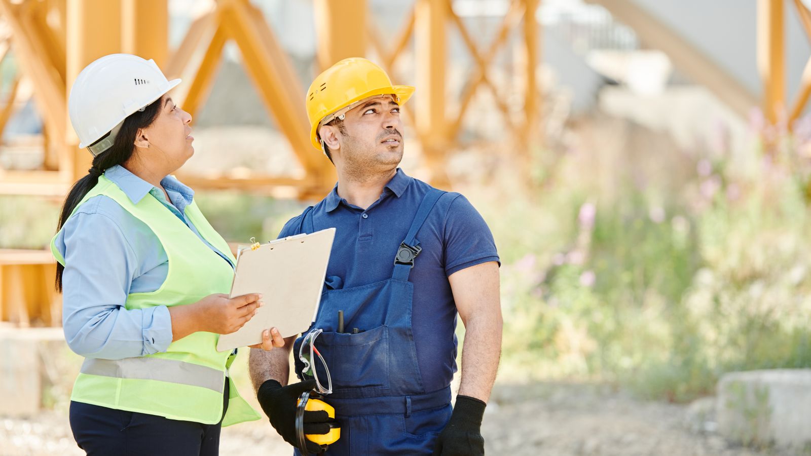 Safety consultant with a clipboard reviewing a construction site, showing what triggers an OSHA inspection during a site walkthrough