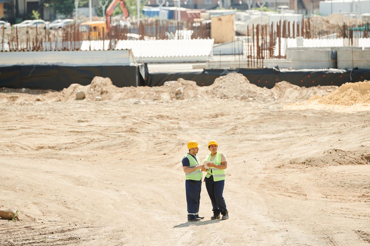 Two safety consultants completing a PPE hazard assessment walkthrough on a construction jobsite