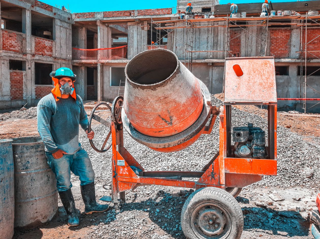 Construction worker wearing a respirator, hard hat, and boots selected from a PPE hazard assessment