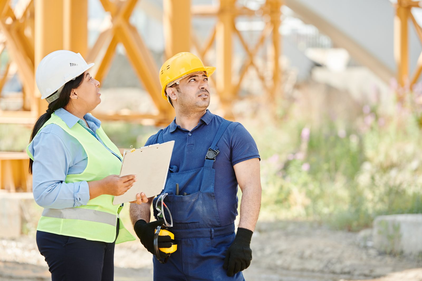 Safety professional and a worker reviewing site records together on a construction project