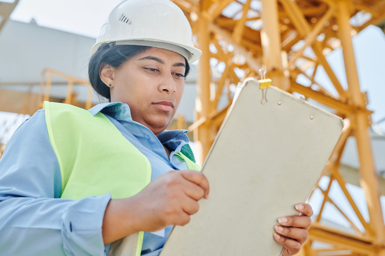 Site safety manager completing recordkeeping forms on a jobsite clipboard