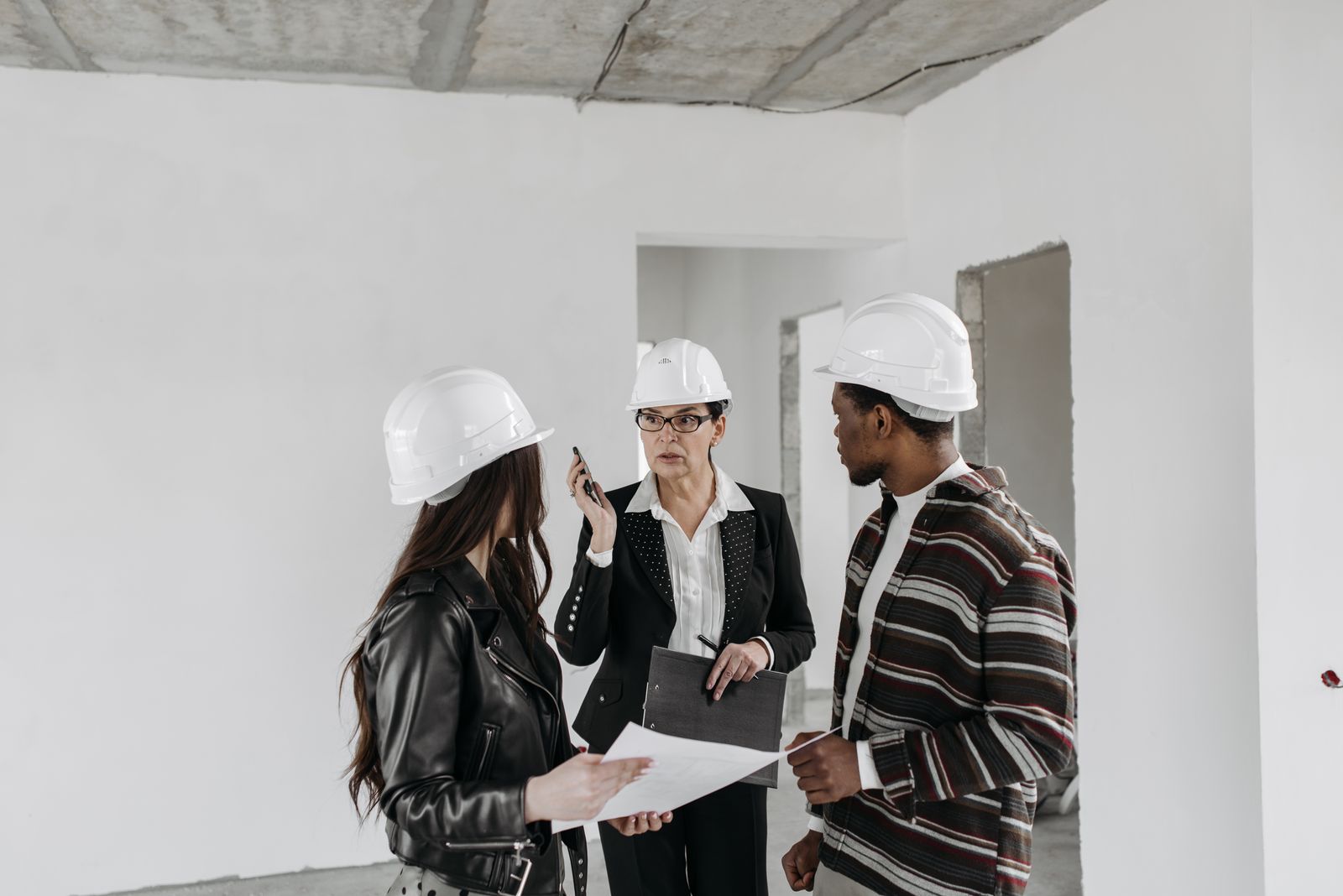 Construction team reviewing plans inside an unfinished building, the setting for what is a toolbox talk in practice